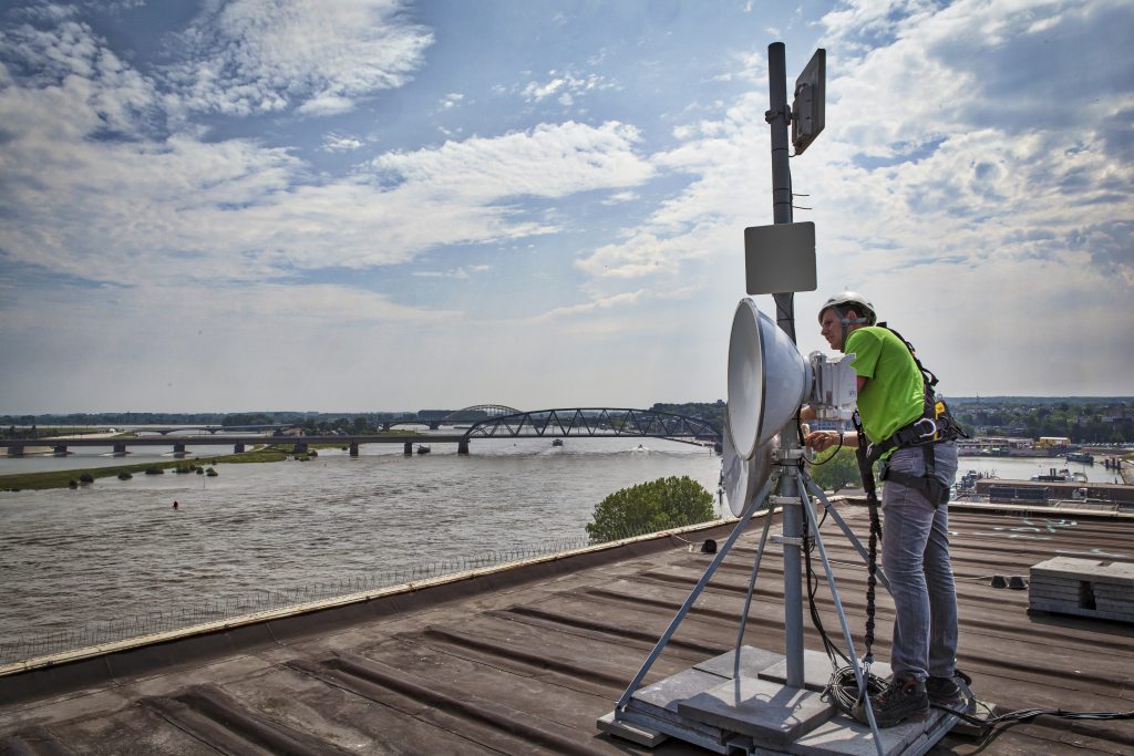 Technicus installeert antenne op dak.