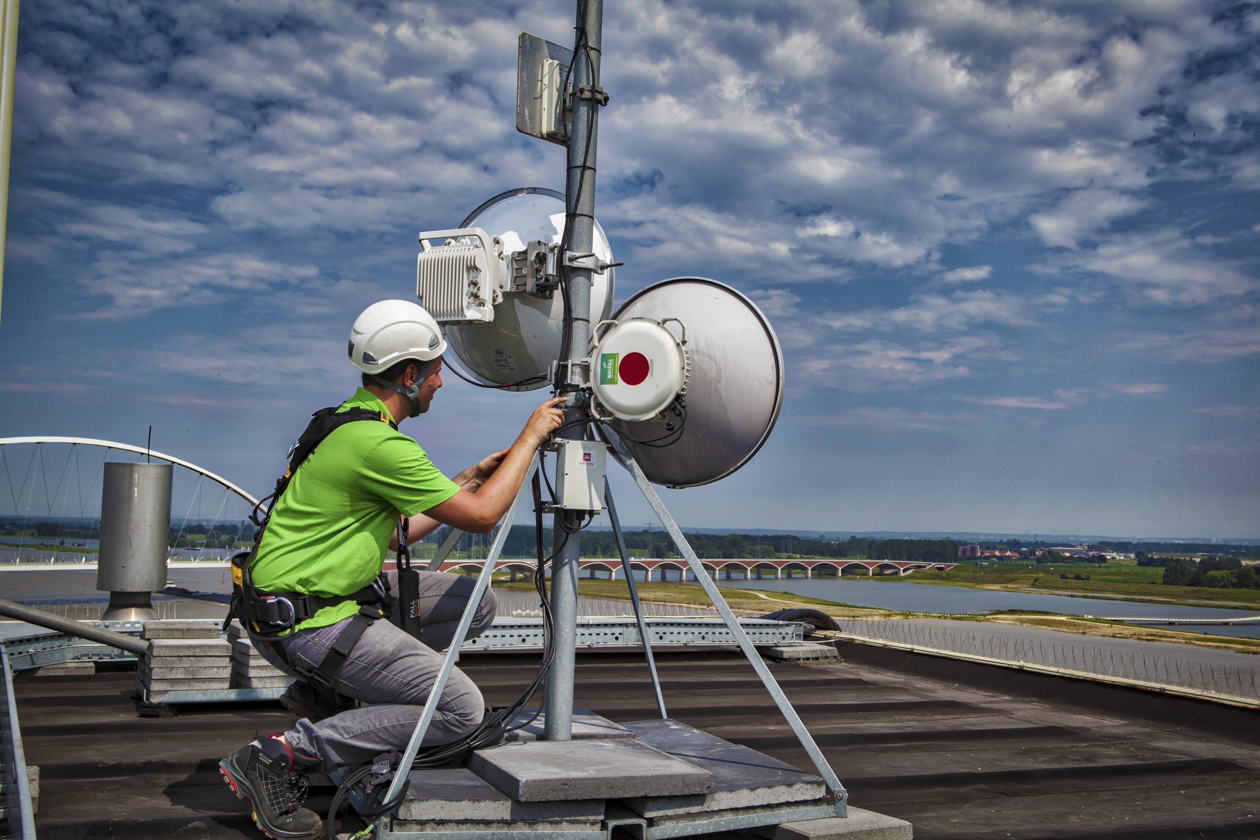 WiFi4ALL technicus installeert antenne op dak.